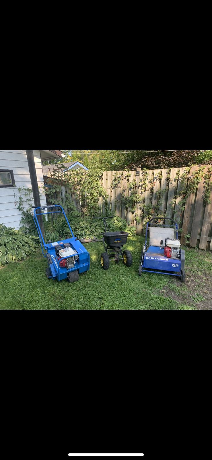 Core aerator and fertilizer spreader equipment on a Thunder Bay lawn